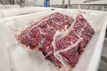 Large cuts of beef packed in a vacuum plastic bag.