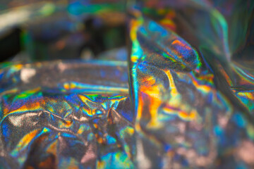 Iridescent fabric holographic background. Crumpled foil surface