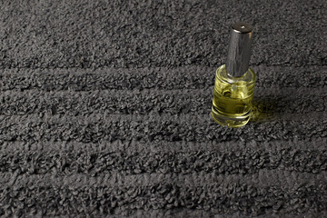 A bottle of oil on a gray towel background. Spa at home, safety
