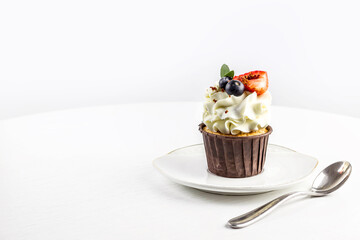 Delicious cupcake with cream and fresh berries .