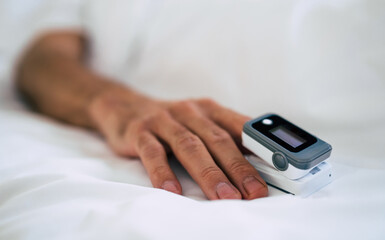 Close up photo of pulse oximeter on the patient finger in the hospital ward
