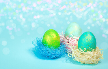 Fototapeta na wymiar Three Easter eggs in a nest on a pink background.
