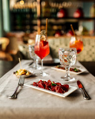 Served restaurant table with aperitif cocktails and mediterranean appetizers 