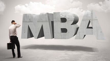 Rear view of a businessman standing in front of MBA abbreviation, modern technology concept