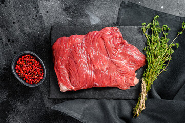 Raw outside skirt steak, marbled meat. Black background. Top view