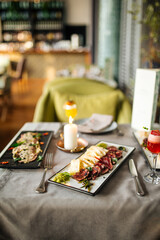 Side view on restaurant table served with European fusion cuisine appetizers