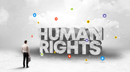 Young businessman standing in front of HUMAN RIGHTS inscription, social media concept