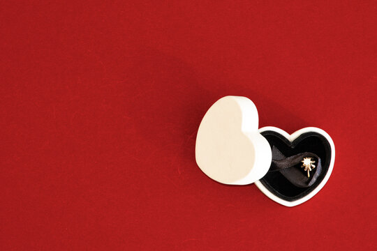 Caja destapada con forma de coraz&oacute;n con anillo en interior de compromiso 