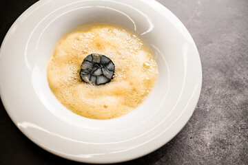 view of white round plate with yellow foam with large sushi roll inside