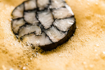 close-up view of delicious slice of fish roll in yellow whipped froth