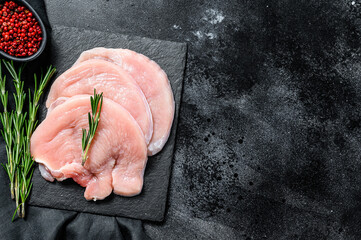 Raw Turkey breast steaks. organic poultry meat. Black background. Top view. Copy space