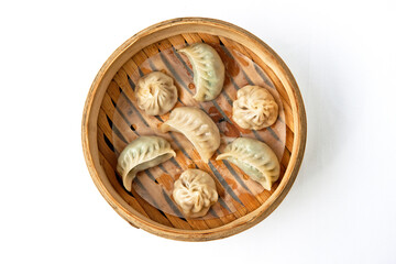 Oriental traditional chinese dumplings served in bamboo wood steamer placed white background