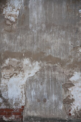fragment of an old brick wall with concrete plaster and remnants of multicolored paint, grunge,...