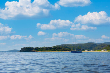 Fototapeta na wymiar Sail boat, yacht in a beautiful bay with blue water during sunny day, Chalkidiki, Greece