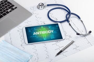 Tablet pc and doctor tools with ANTIBODY inscription, coronavirus concept