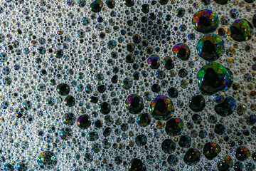 Shot from above of soap bubbles with brilliant oil colors, caused by interference of light