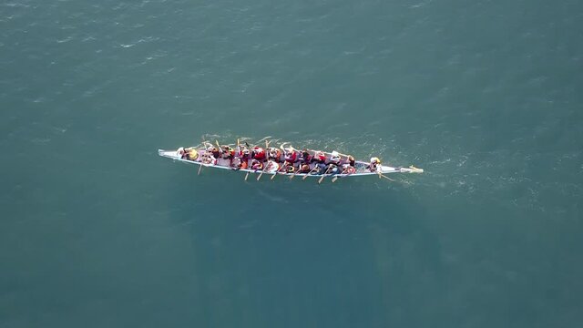 Dragon Boat team rowing together. Teamwork on Dragon Boat at sea. 