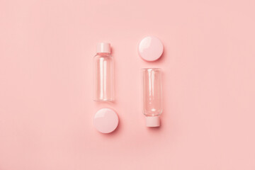 Empty tubes for cosmetics on a pastel pink background. Flat lay, top view. Banner