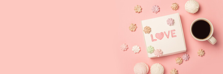 Fototapeta na wymiar Gift box, cup with coffee, meringue and sweets on a pink background. Composition Valentine's Day. Banner. Flat lay, top view