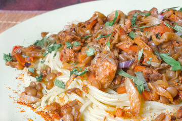 bolognese pasta with lentils on a light green plate close-up