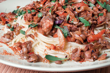 bolognese pasta with lentils on a light green plate close-up