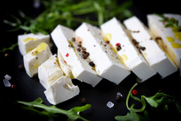 Soft focus. Fresh feta cheese on a black stone board.