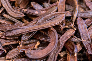 Close up of carob pods heap or Ceratonia siliqua background