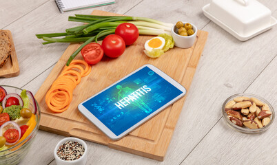 HEPATITIS concept in tablet with fruits, top view