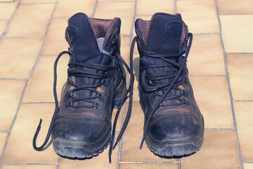 a pair of used dusty and dirty leather brown hiking boots