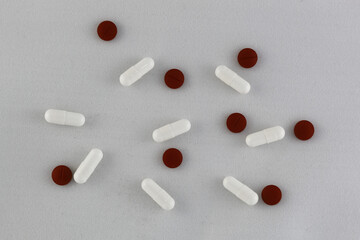 top view of mix of white and red pills on white background