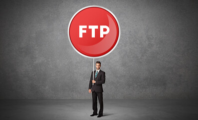 Young business person holdig traffic sign with FTP abbreviation, technology solution concept