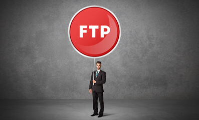 Young business person holdig traffic sign with FTP abbreviation, technology solution concept