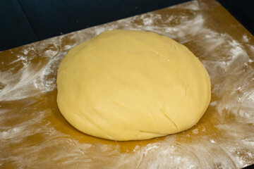 Ready dough on a black table and a silicone mat