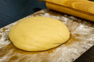 Ready dough on a black table and a silicone mat