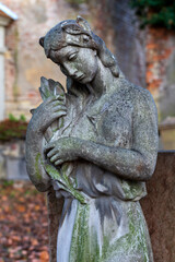 Fototapeta na wymiar Historic Statue on the winter mystery old Prague Cemetery, Czech Republic