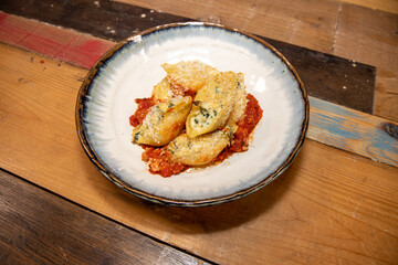 A plate of delicious Spinach and Ricotta pasta shells on a wooden kitchen work top
