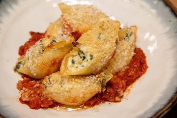 A plate of delicious Spinach and Ricotta pasta shells on a wooden kitchen work top