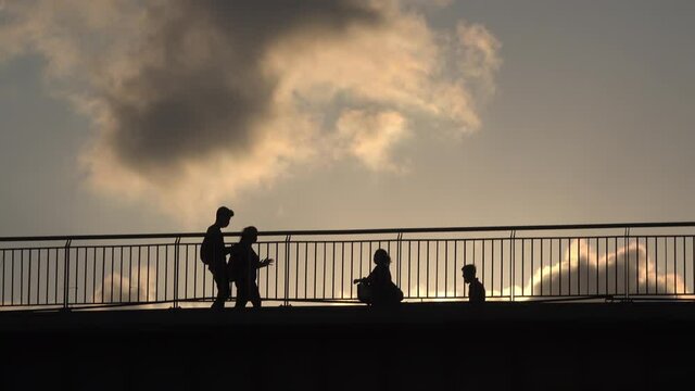 Silhouette Lovers on the bridge. silhouette people walking on the bridge sunset. young girl and boy arguing on the bridge
young girl and boy arguing on the bridge.
