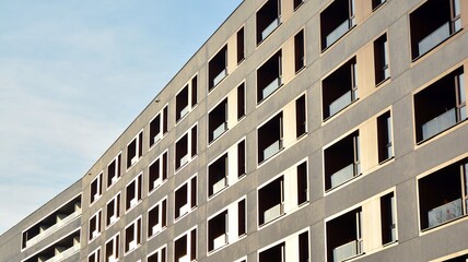 Facade of new apartment building. Glass balcony and clean look of modern architecture building with blue sky background.