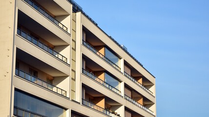 Facade of new apartment building. Glass balcony and clean look of modern architecture building with blue sky background.