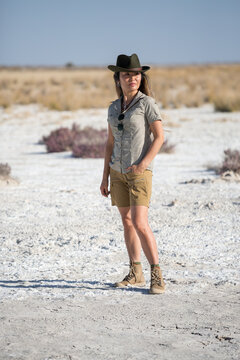 Namibia, Africa, June 18, 2019: Young beautiful tourist woman in shorts and a cowboy hat stands in the middle of the white desert