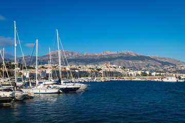 Fototapeta na wymiar Yachts at the port of Altea with view on mountain range with old city and cathedral, Altea, Costa Blanca, Spain
