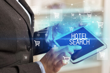 Young person makes a purchase through online shopping application with HOTEL SEARCH inscription