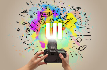 Close-up of a hand holding digital camera with abstract drawing and UI inscription