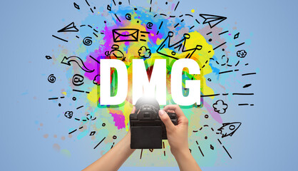 Close-up of a hand holding digital camera with abstract drawing and DMG inscription