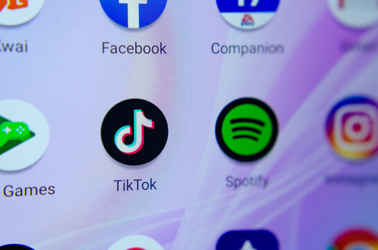 Stone, Staffordshire / United Kingdom - June 12 2019: TikTok and Spotify apps on the smartphone screen. Macro photo. TikTok is getting into the streaming music business. Editorial Illustrative image.
