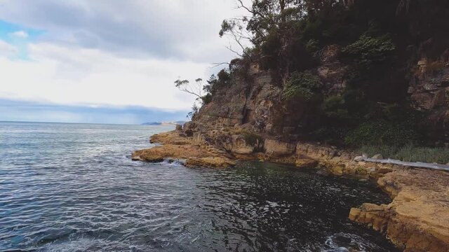 pristine wild landscape at Boronia Beach in Tasmania, Australia with lush vegetation and rocks on the shore