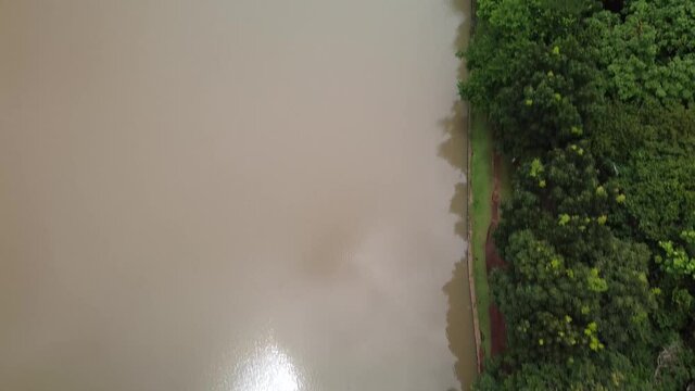 Drone voando sobre um lago e uma floresta mostrando o reflexo do lago