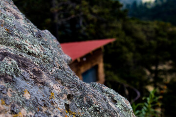 ROCA CON FONDO DE CABAÑA ECOTURISTICA