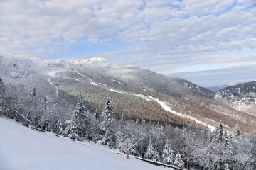 Fototapeta na wymiar Stowe Ski Resort in Vermont, view to the Mansfield mountain slopes, December fresh snow on trees early season in VT, panoramic hi-resolution image
